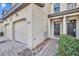 Townhome entrance with two-car garage and walkway at 8177 Roseville Blvd, Davenport, FL 33896