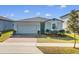 New home exterior with gray siding, two-car garage, and well-maintained lawn at 841 Teton St, Haines City, FL 33844