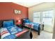 Bedroom with two twin beds and red accent wall at 8923 Shine Dr, Kissimmee, FL 34747