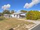 Charming single-story home with light gray exterior, fenced yard and a detached two car garage at 1119 Pine Ave, Tavares, FL 32778