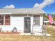 Gray house with black security door, chain link fence, and American flag at 1119 Pine Ave, Tavares, FL 32778