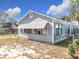 Gray house with awning windows, chain link fence, and American flag visible at 1119 Pine Ave, Tavares, FL 32778