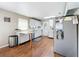 Galley kitchen with white cabinets, stainless steel appliances, and wood-look floors at 1119 Pine Ave, Tavares, FL 32778