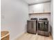 Laundry room with modern washer and dryer and white cabinets at 1203 Waverly Way, Longwood, FL 32750