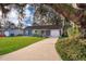 Charming single-story home featuring a well-manicured lawn, covered porch with rocking chairs, and an attached garage at 1222 Golfview St, Orlando, FL 32804