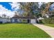 Charming single-story home featuring a well-manicured lawn, mature trees, and a welcoming facade at 1222 Golfview St, Orlando, FL 32804