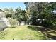 Large grassy backyard with mature trees and a white vinyl fence at 127 Kaywood Dr, Sanford, FL 32771