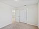 Simple bedroom with carpet, door to bathroom and double door closet at 1274 Shoreside St, Clermont, FL 34714