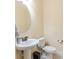 Simple, clean bathroom with pedestal sink and oval mirror at 12964 Brandon Coates Dr, Orlando, FL 32828