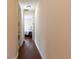 Long hallway with hardwood floors and access to laundry and bedroom at 12964 Brandon Coates Dr, Orlando, FL 32828