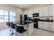 Well-equipped kitchen with white cabinets and black countertops at 12964 Brandon Coates Dr, Orlando, FL 32828