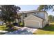 Two-story house with beige exterior, large garage, and landscaping at 13214 Meergate Cir, Orlando, FL 32837