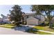 Two-story house with beige exterior, large garage, and landscaping at 13214 Meergate Cir, Orlando, FL 32837