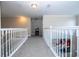 Upstairs hallway with carpeted floors and white railings at 13214 Meergate Cir, Orlando, FL 32837