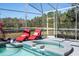 Screened pool and spa with lounge chairs, overlooking a lake at 13214 Meergate Cir, Orlando, FL 32837