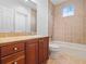 Simple bathroom with a bathtub and wooden cabinets at 1470 Place Picardy, Winter Park, FL 32789