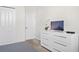 Bedroom with white dresser, TV, and double doors at 1551 Flange Dr, Davenport, FL 33896