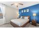 Bedroom with wood bed frame, blue accents, and ceiling fan at 1551 Flange Dr, Davenport, FL 33896