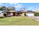 Single-story house with solar panels, attached garage, and well-maintained lawn at 1640 Templewood Ave, Deltona, FL 32725