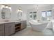 Bathroom with double vanity, free-standing tub, and herringbone tile at 1812 Turnberry Ter, Orlando, FL 32804