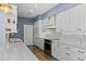 White kitchen with marble backsplash, stainless steel appliances, and a farmhouse sink at 1812 Turnberry Ter, Orlando, FL 32804