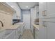 Well-equipped laundry room with white cabinets, a farmhouse sink, and patterned flooring at 1812 Turnberry Ter, Orlando, FL 32804