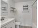 Bright bathroom featuring a white vanity, mirror, shelving, and bathtub at 1834 Roper Rd, St Cloud, FL 34771