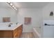 Well-lit bathroom with double sinks, wooden cabinets, and a large soaking tub at 1834 Roper Rd, St Cloud, FL 34771