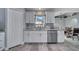 Kitchen area with stainless steel dishwasher, wood-look floors, and a sunny window view at 1834 Roper Rd, St Cloud, FL 34771