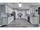 Modern kitchen with stainless steel appliances, light gray countertops, white cabinets, and wood-look flooring at 1834 Roper Rd, St Cloud, FL 34771