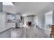 Open concept living space with sleek wood-look floors connecting the kitchen, dining area, and a cozy nook at 1834 Roper Rd, St Cloud, FL 34771