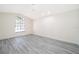 Simple bedroom with gray vinyl plank flooring and a large window with blinds at 2006 Key Lime St, Ocoee, FL 34761