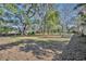 Open backyard with mature trees and grassy area at 2323 Tuskawilla Rd, Oviedo, FL 32765