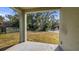 Covered back patio overlooks a grassy yard with mature trees and a wooden fence at 24414 Woodhill Ct, Sorrento, FL 32776