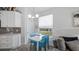 Bright breakfast nook features a white table with blue chairs, adjacent to a kitchen at 24414 Woodhill Ct, Sorrento, FL 32776