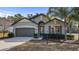 Single-story home with two-car garage, landscaping, and inviting curb appeal at 24414 Woodhill Ct, Sorrento, FL 32776