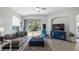 Spacious living room with gray sofa, blue armchair, and sliding glass doors at 24414 Woodhill Ct, Sorrento, FL 32776