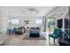 Living room with gray sectional, blue accent chair, and large windows at 24414 Woodhill Ct, Sorrento, FL 32776