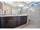 Double vanity bathroom with granite countertops and a large walk-in shower at 305 Silver Maple Rd, Groveland, FL 34736