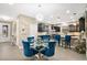 Bright dining area with a glass table and four blue velvet chairs at 305 Silver Maple Rd, Groveland, FL 34736