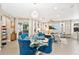 Open concept dining area featuring a glass table and blue chairs, adjacent to the living room at 305 Silver Maple Rd, Groveland, FL 34736