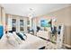 Spacious main bedroom featuring a blue velvet bed, white bedding, and a large TV at 305 Silver Maple Rd, Groveland, FL 34736