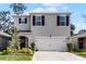 Two-story house with gray siding, brown shutters, and a two-car garage at 325 Pelham Park Dr, Deland, FL 32720