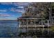 Rustic lakefront dock with covered boathouse and lily pads at 3818 Kinsley Place, Winter Park, FL 32792