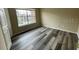 Well-lit bedroom showcasing wood-look floors and a door at 5545 Devonbriar Way # 205, Orlando, FL 32822