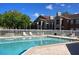 Community pool with surrounding patio and lounge chairs at 5545 Devonbriar Way # 205, Orlando, FL 32822