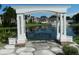 Serene waterfront view with pergola and bench at 5545 Devonbriar Way # 205, Orlando, FL 32822