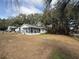 Ranch home with a large yard, fire pit, and partial view of a barn at 5690 Sw 202Nd Ct, Dunnellon, FL 34431