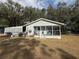 Light blue ranch home with covered porch and spacious yard at 5690 Sw 202Nd Ct, Dunnellon, FL 34431