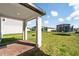 Covered patio leading to a spacious backyard with lush green grass and a trampoline at 581 Sun Warbler Way, St Cloud, FL 34771